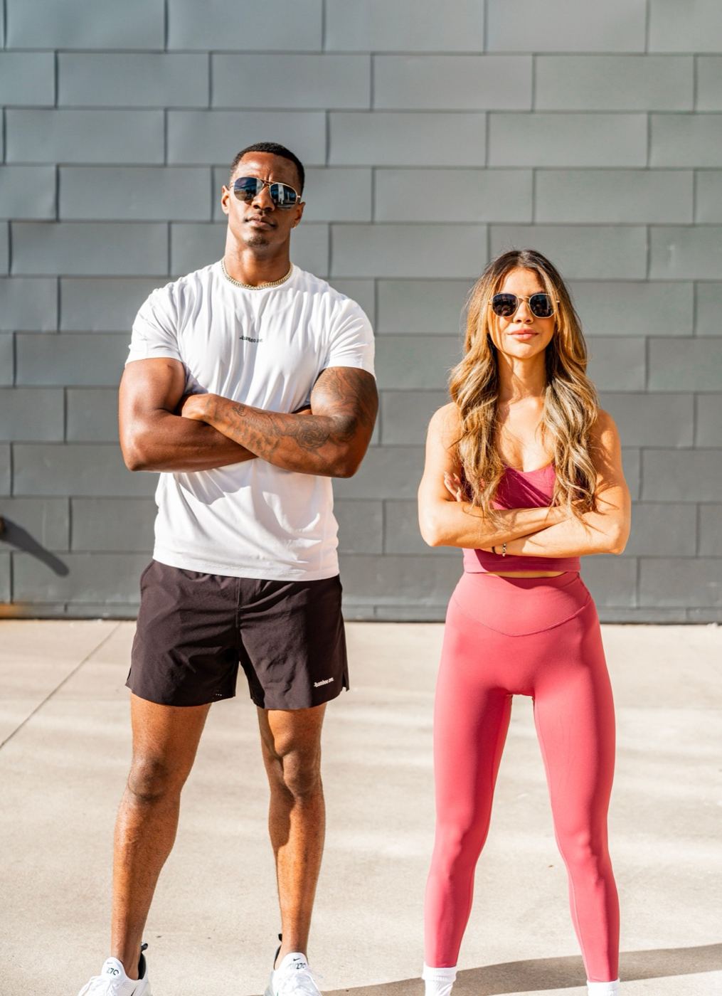 Man and woman in sportswear standing outside a modern London-style building