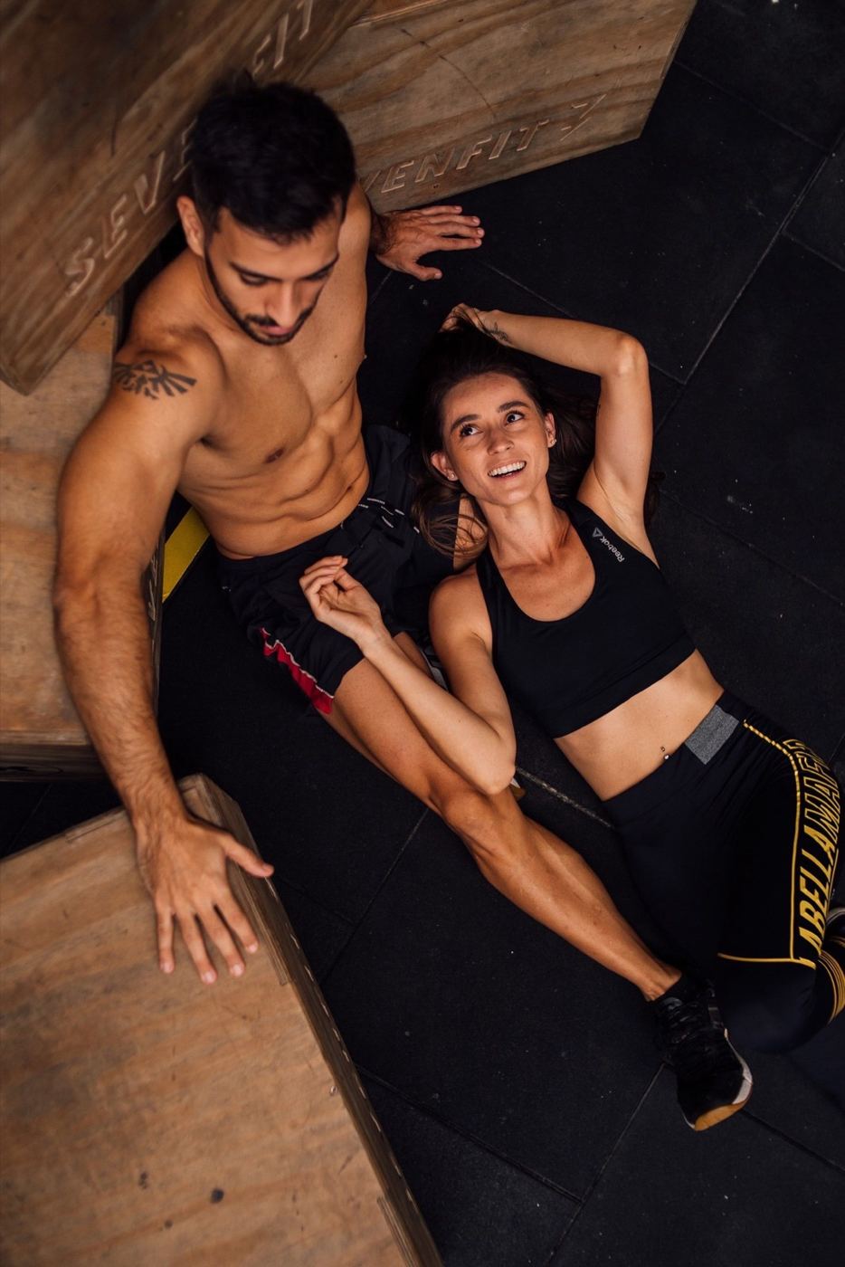 Two people stretching on a gym floor