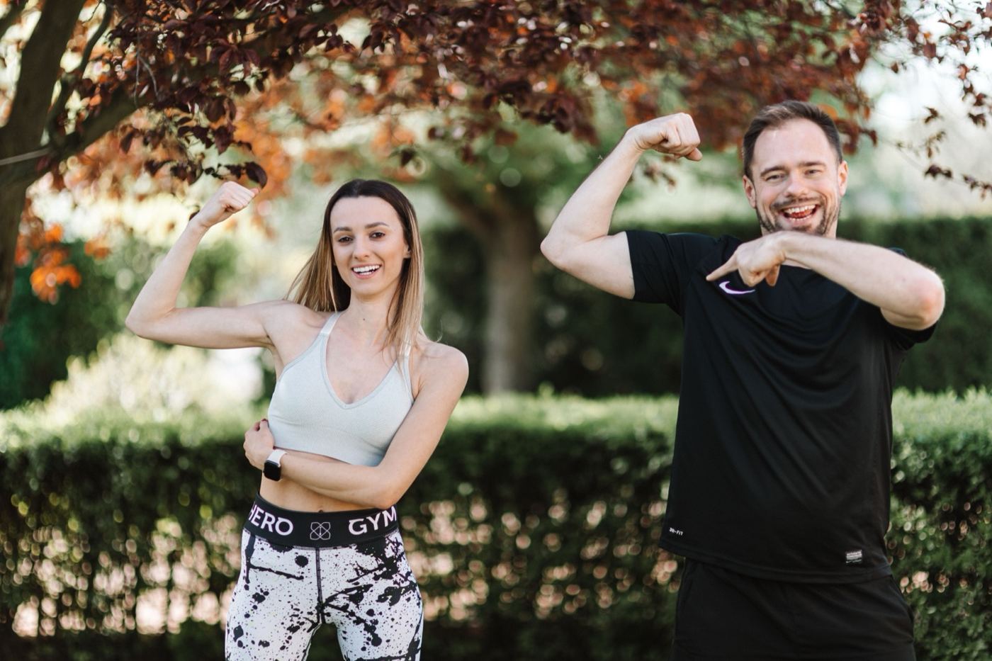 Couple stretching together on a leafy park path